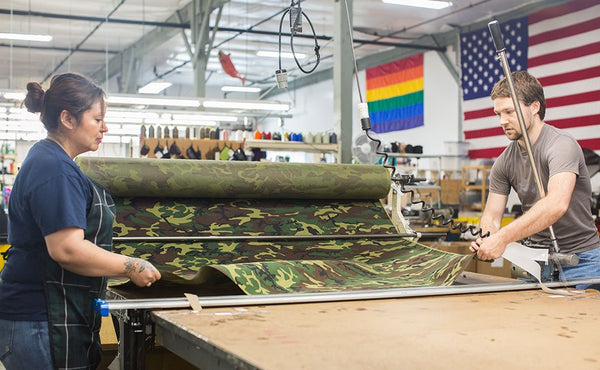 Two people unrolling the Beaver Camo used on the Beaver Transfer Bags